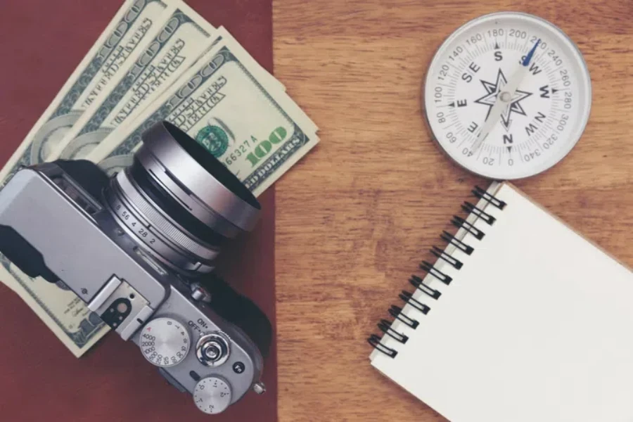 Vintage camera with paper note on wooden table.Budget plan travel concept