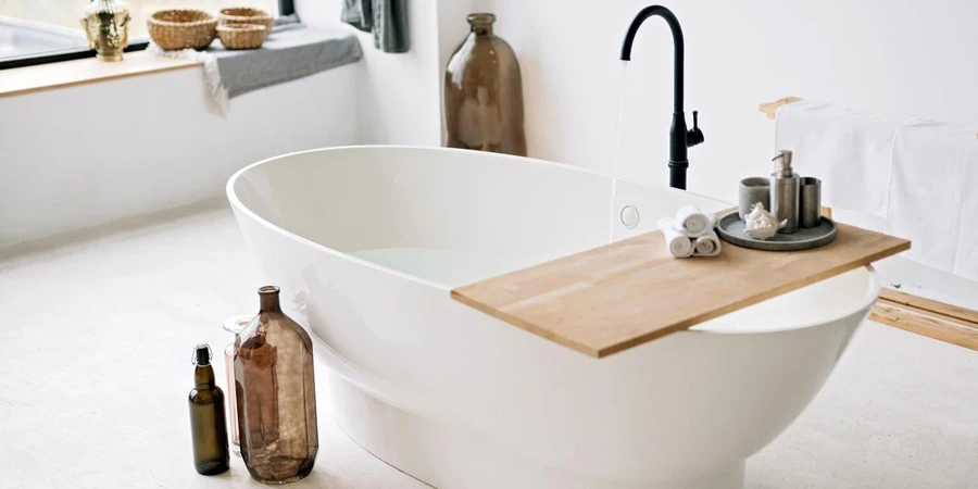 White bathtub fills with foam water in a modern apartment with stylish loft-style interior design, home decor.