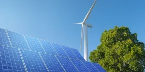 Wind turbine with solar panels in blue sky