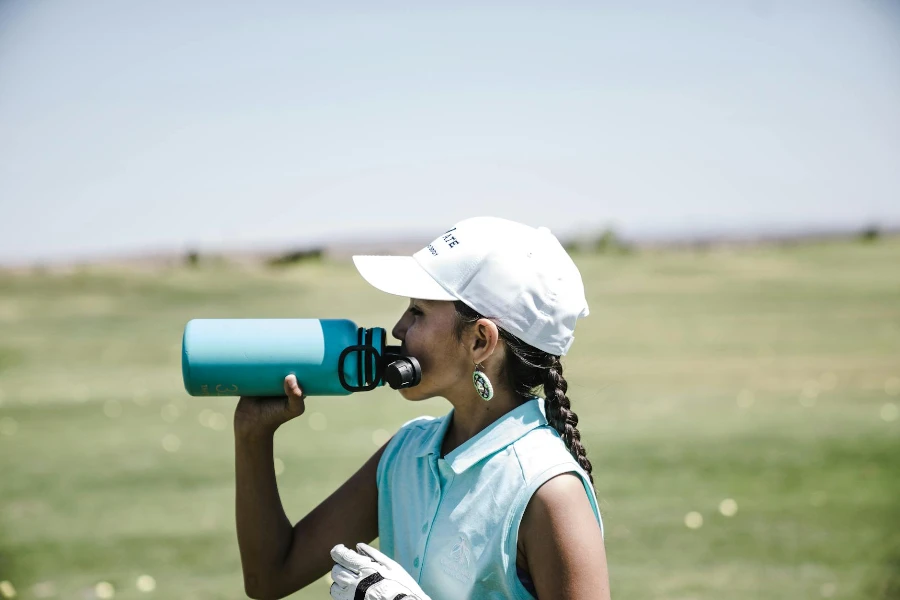 Woman Drinking at Blue Sports Bottle Outdoors