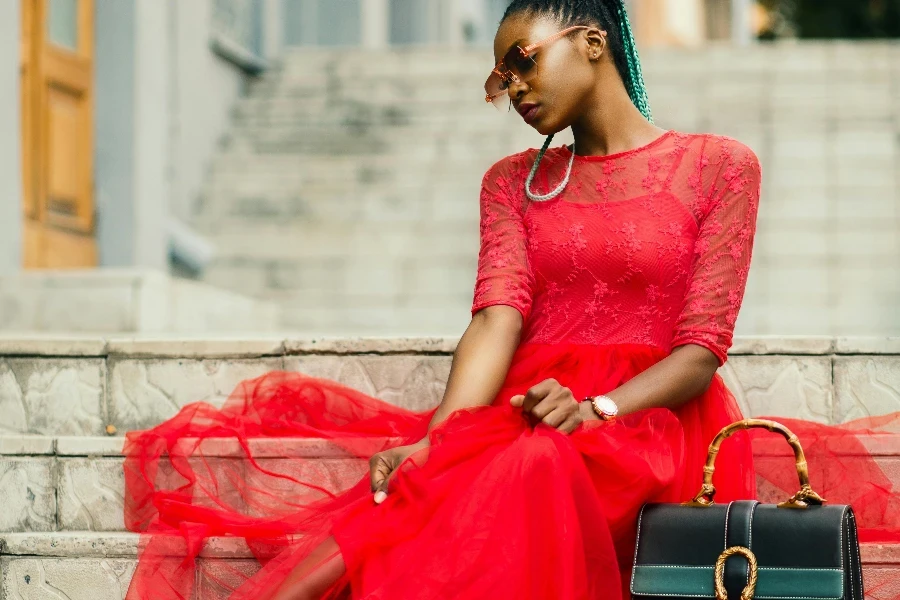 Woman Wearing Red Long-sleeved Dress Near Black Leather Bag