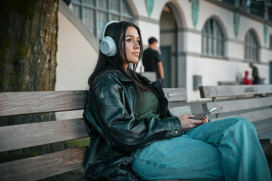 Woman With Headphones Sitting on Wooden Bench