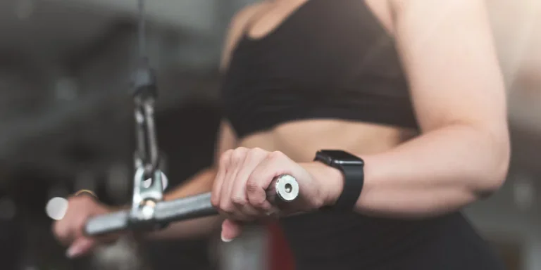 Woman-doing-triceps-exercise-by-machine-in-sunlight-closeup