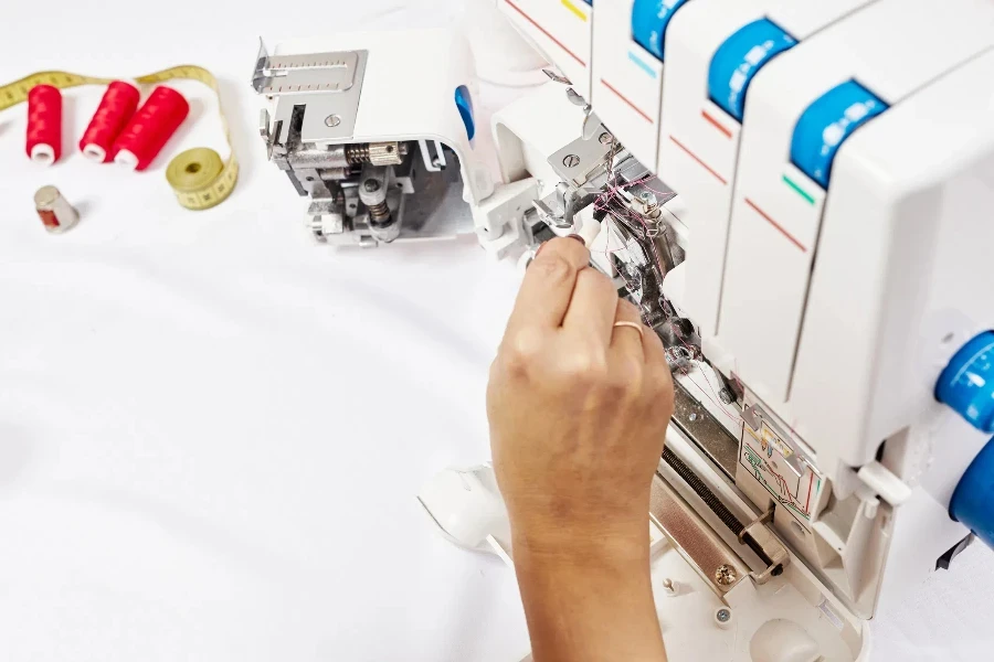 Woman hands cleaning the sewing machine with brush