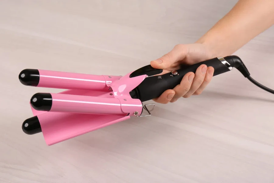 Woman holding modern triple curling iron