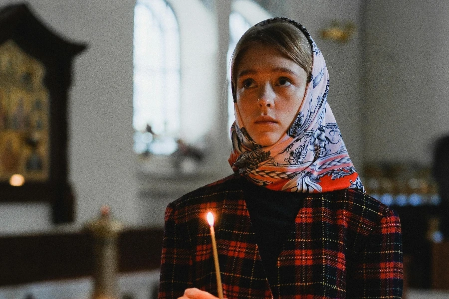 Woman in Head Scarf Holding Lighted Candle