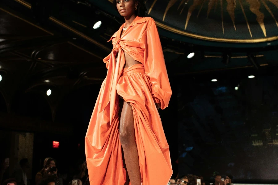 Woman in Orange Robe Standing on White Floor