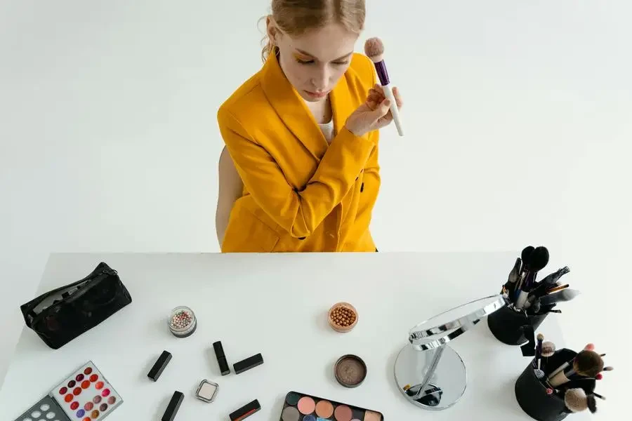 Woman in Yellow Blazer Holding Makeup Brush by MART PRODUCTION