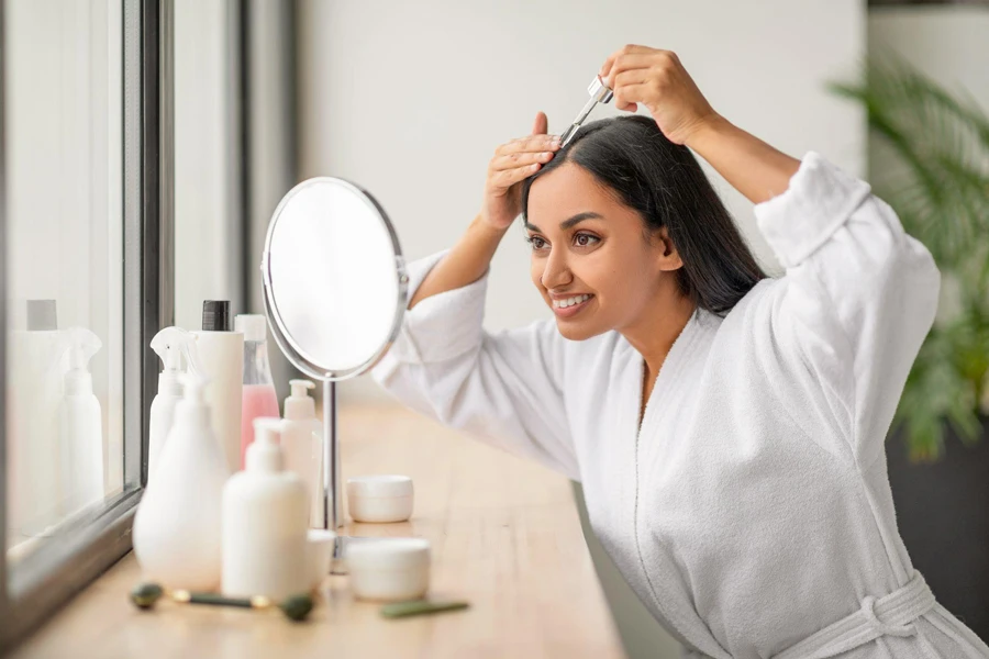 Woman looking in the mirror and taking care of her scalp