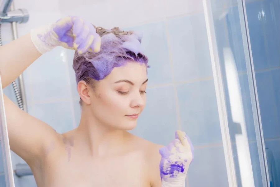 Woman waiting for purple shampoo on her hair work