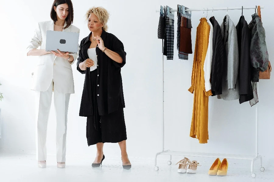 Women Standing Beside a Clothing Rack