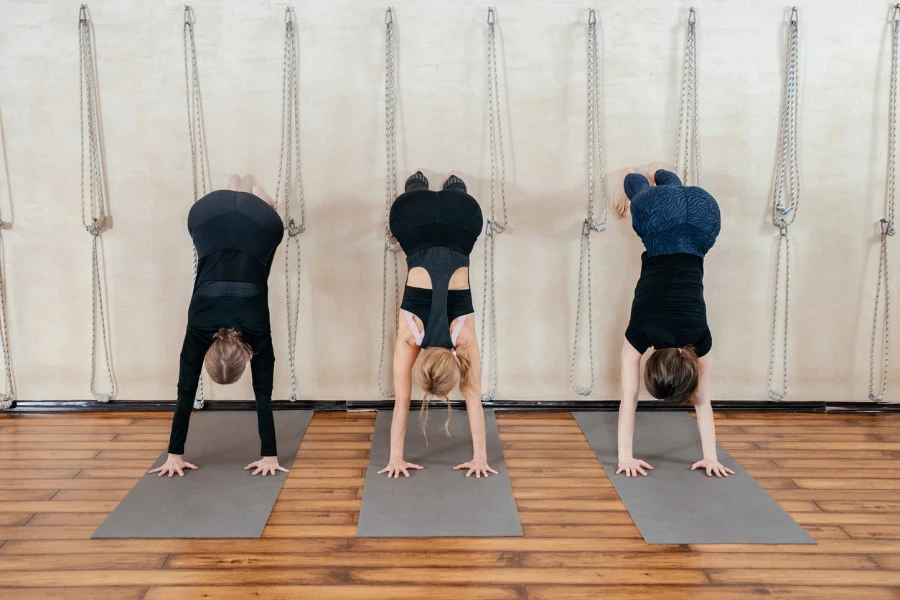 Women learning to stand on hands near wall