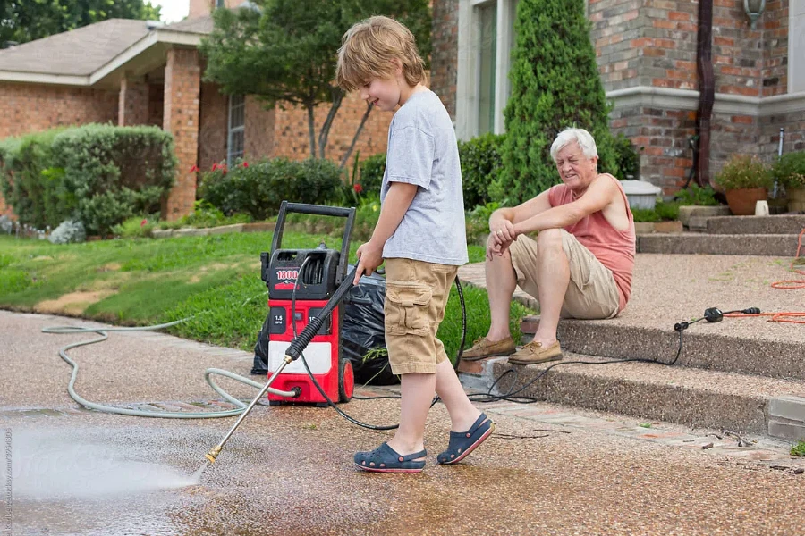 Young Boy Power Washing Driveway