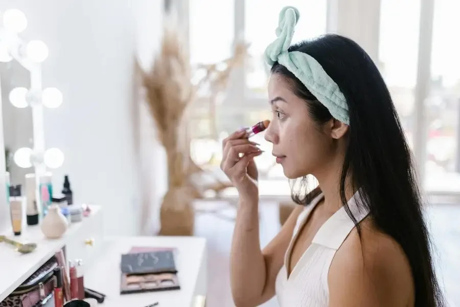 Young Woman Doing Makeup at Vanity Table by RDNE Stock project