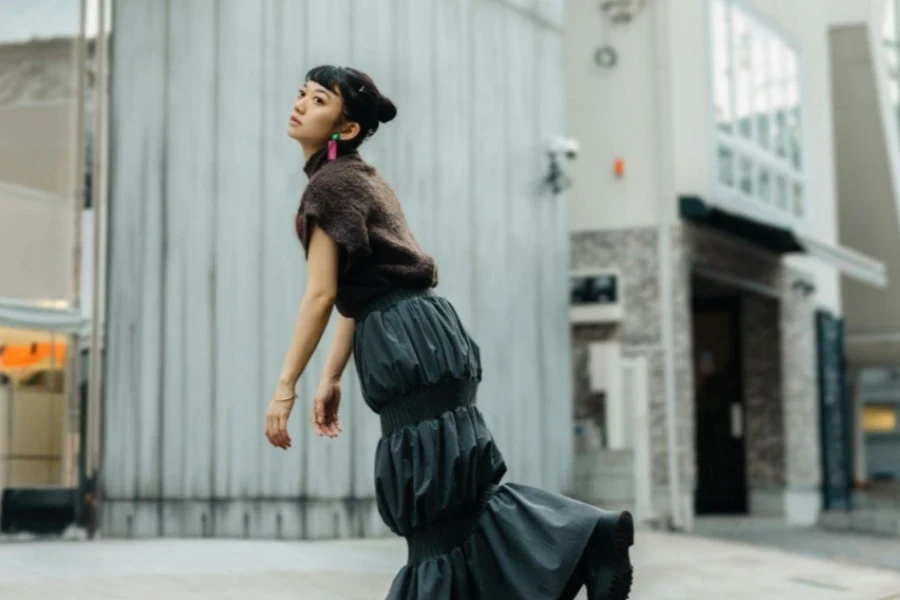 Young Woman in a Midi Skirt Standing on One Leg