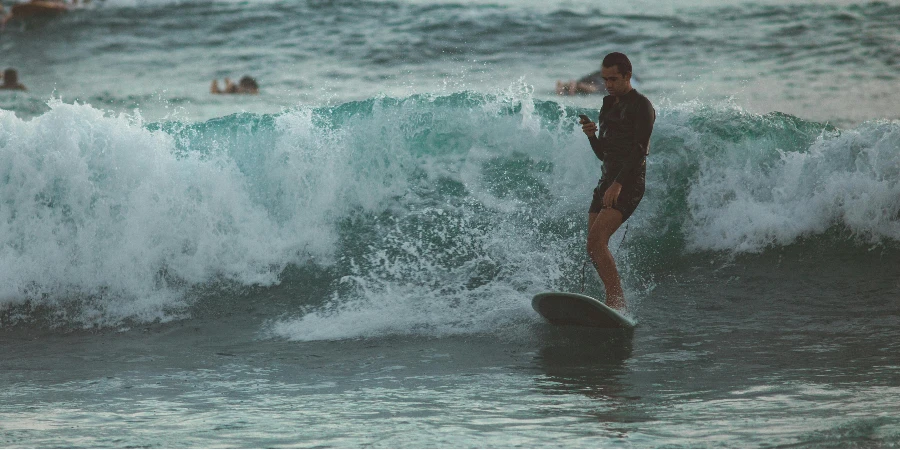 Young male surfer in short wetsuit