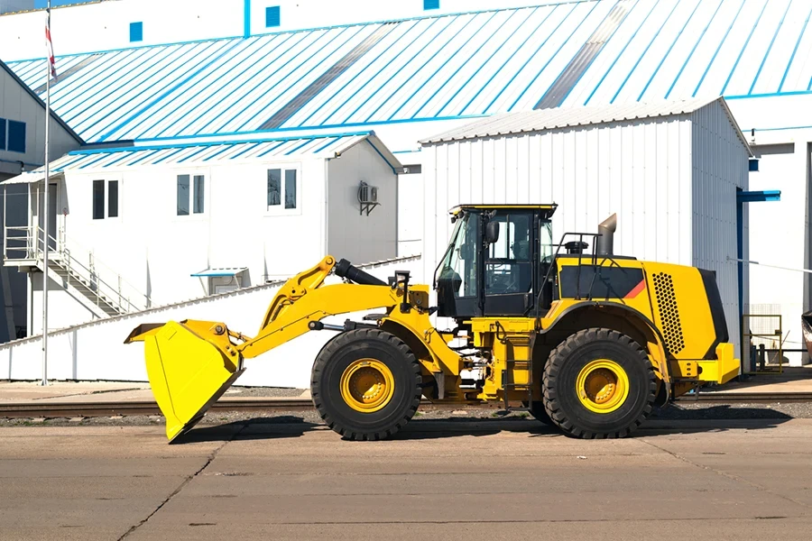 a bulldozer or tractor with a bucket of industrial machinery parked on a construction site or warehouse