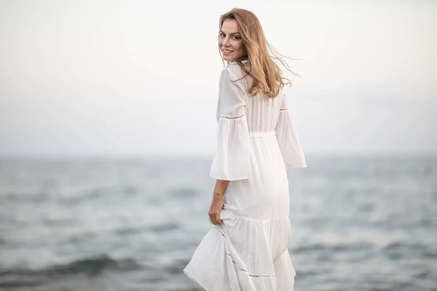 A close up of woman in a white maxi dress