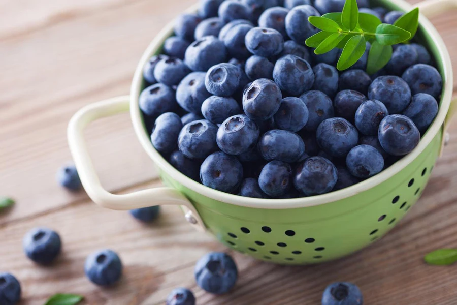 a colander bowl full of blueberries - fruits and vegetables