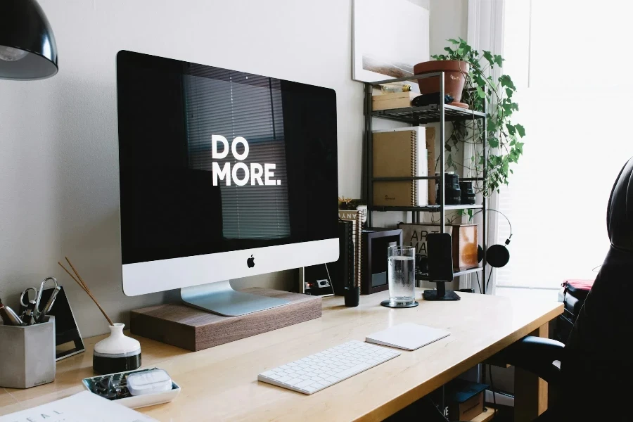 A desktop on an office desk with supplies in containers and a diffuser