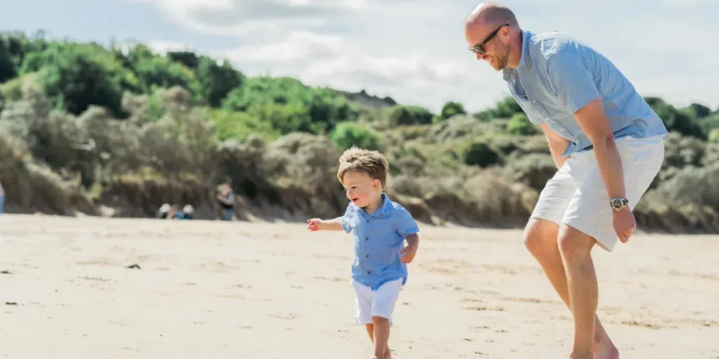 A happy father plays with his son on the beach