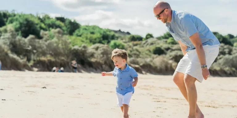 Un père heureux joue avec son fils sur la plage