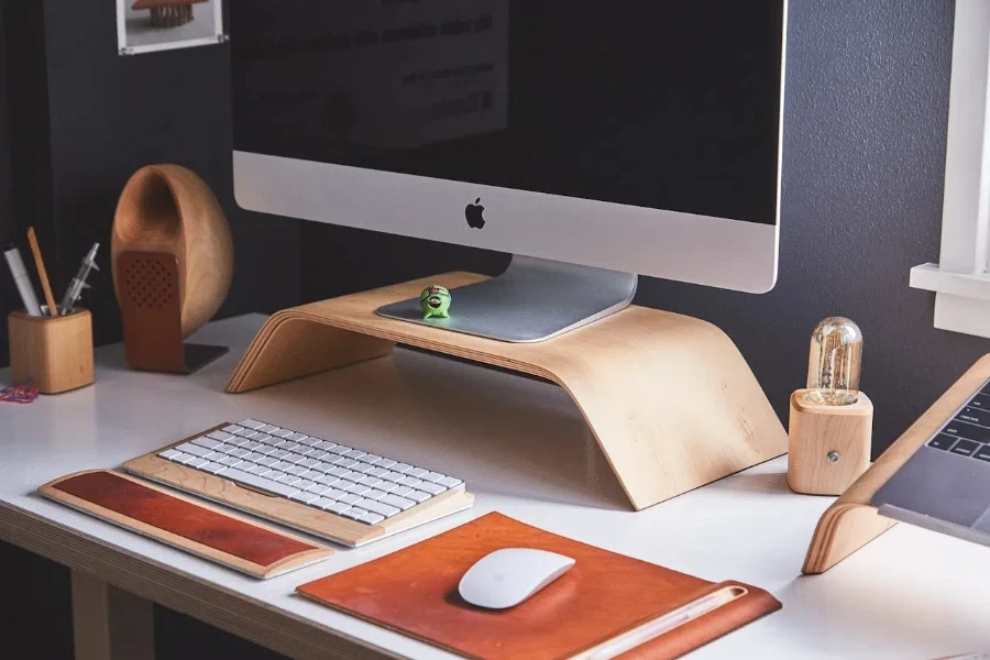 A monitor stand with accessories holder, keyboard and mouse