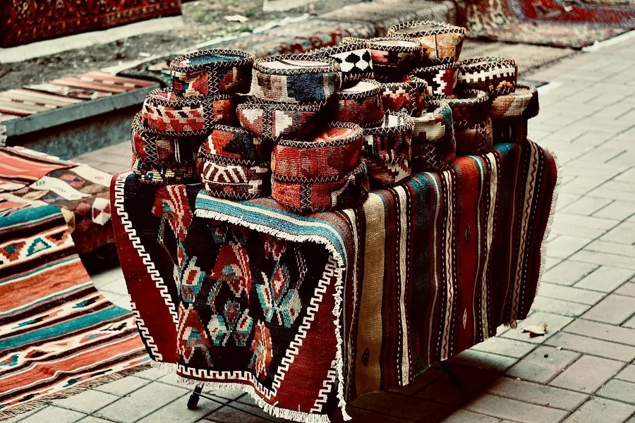 A pile of handmade rugs and baskets