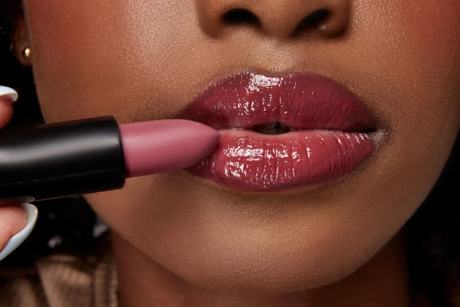 a woman applying matte lipstick