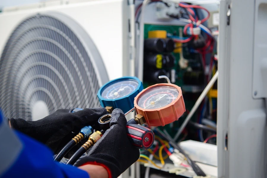 air conditioner technician using manifold gauge checking