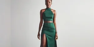 A black woman wearing an emerald green bodycon skirt