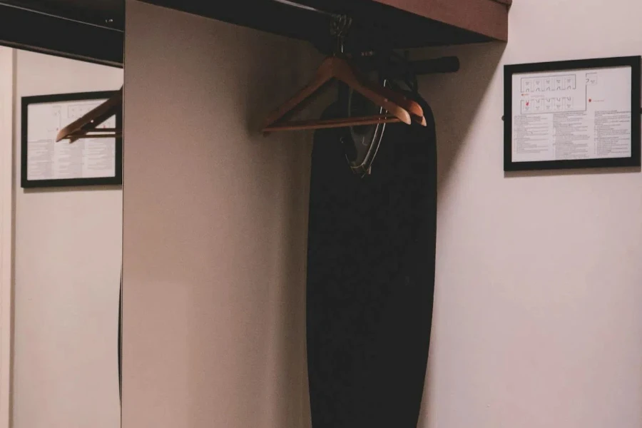 Black ironing board hanging in closet