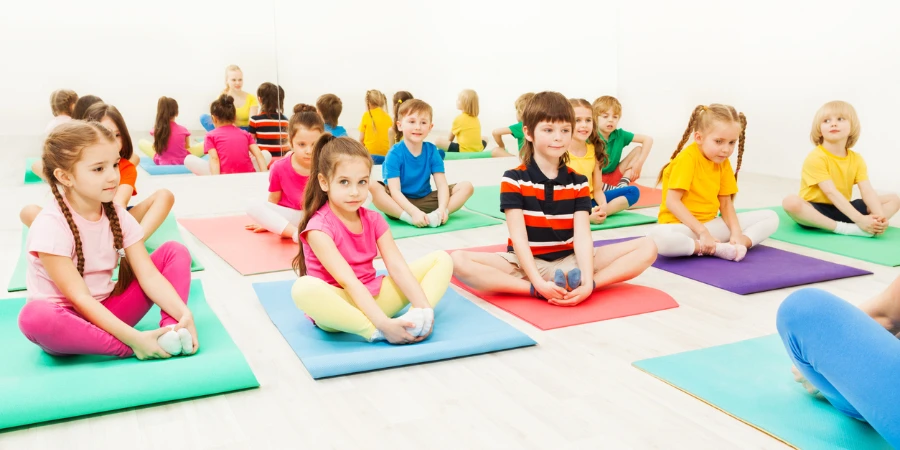 girls doing butterfly exercise sitting on yoga mats in gym