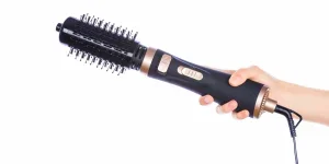 Hand holding hair curling iron round brush