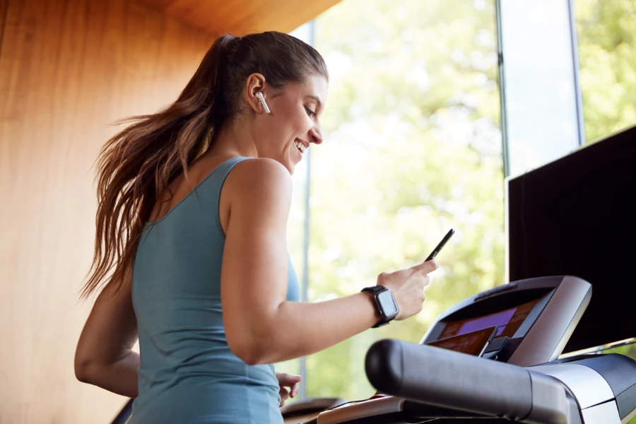 Athletic and sporty woman running on treadmill