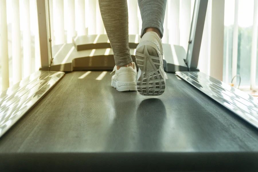 Young woman muscular feet in sneakers running