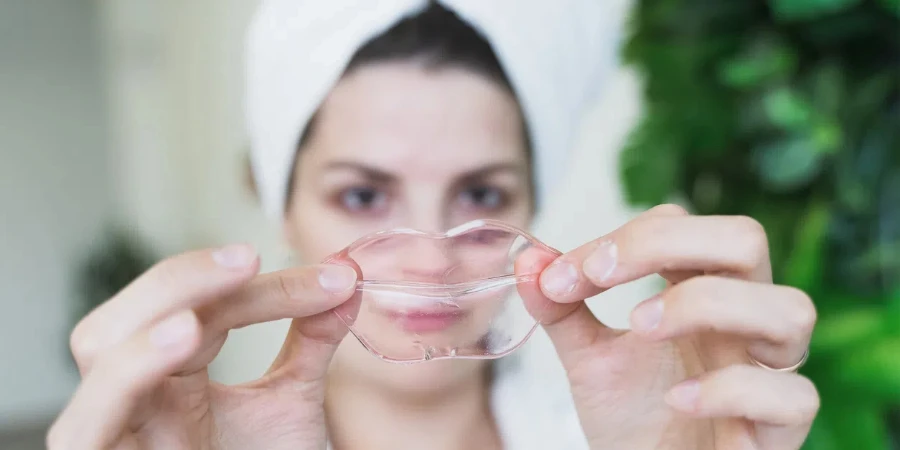 Beautiful young woman uses collagen hydrogel pink lip patch