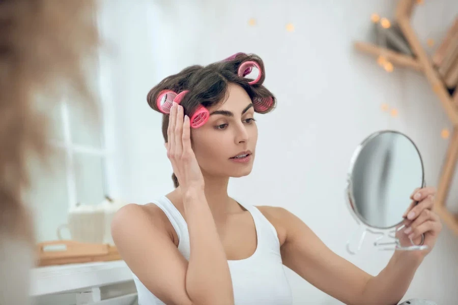 Good-looking young woman in curlers