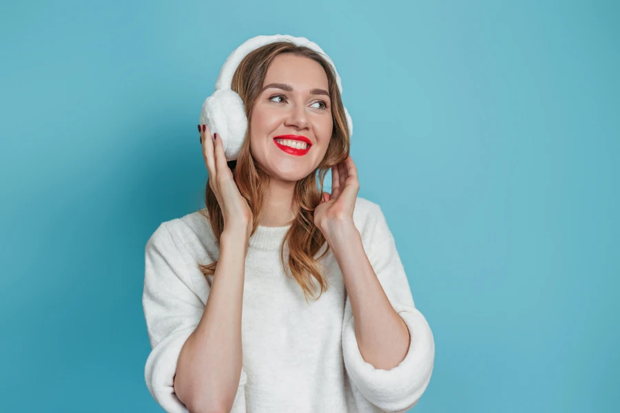 Happy smiling young caucasian woman with fur headphones