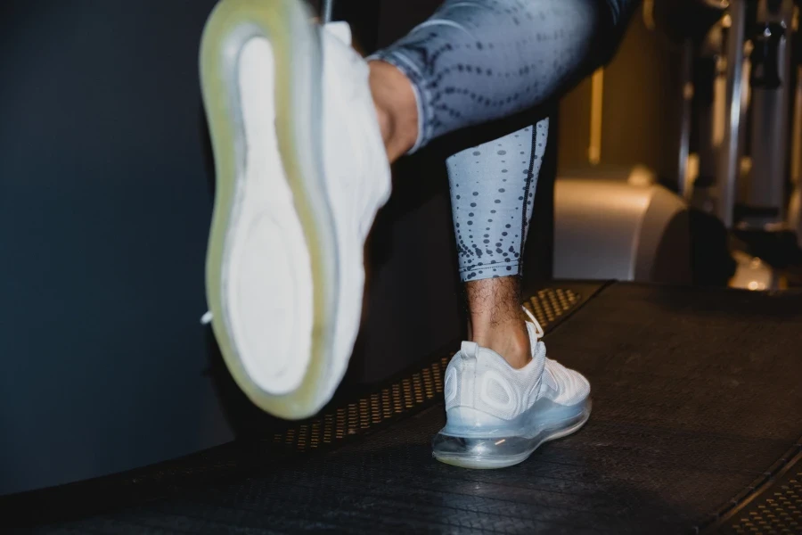 A closeup shot of a male athlete running on a curved treadmill