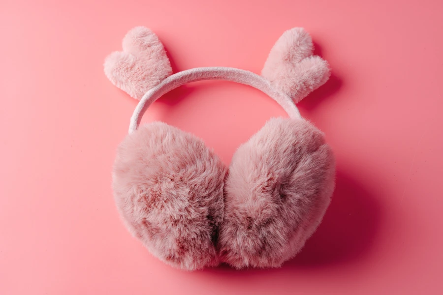 Fluffy warm pink earmuffs on pink background