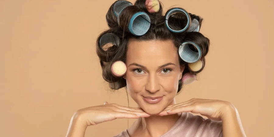 Beautiful smiling woman with hair curlers