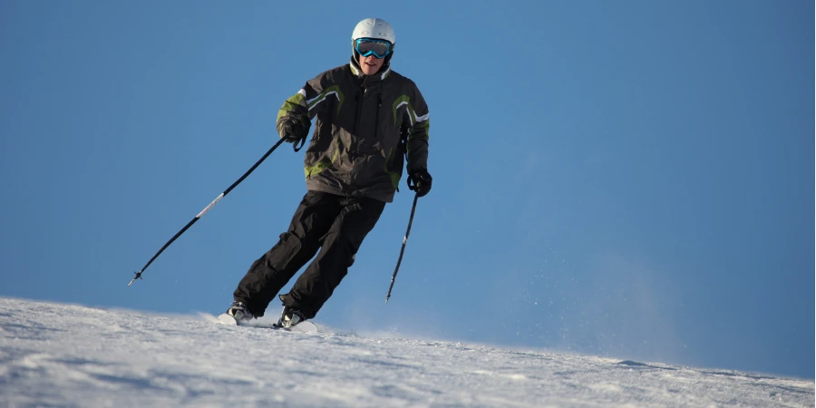 Tiener mannelijke skiër op gepakte poedersneeuw