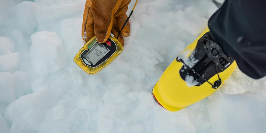 Person holding a modern avalanche beacon in his hands