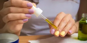 Female hand holding a pipette with oil