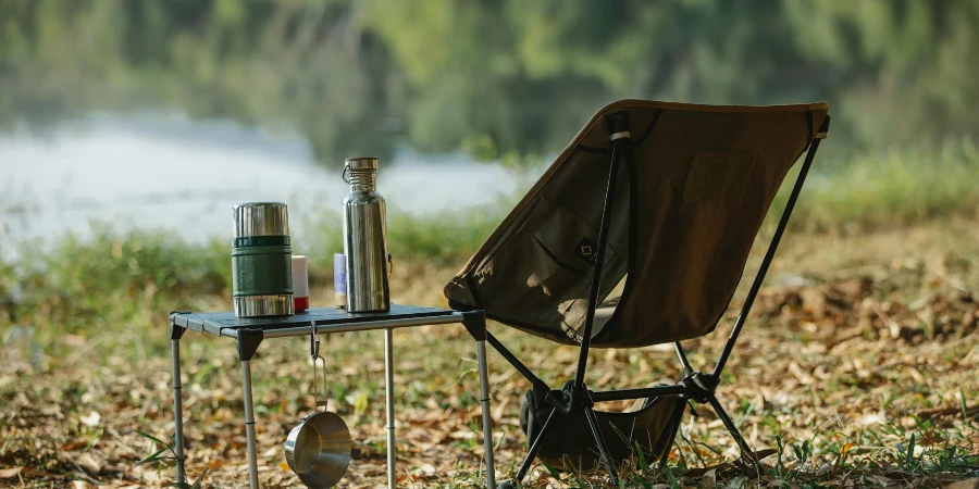 Camping chair near table on river shore