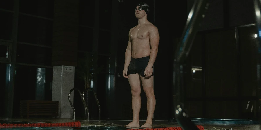 Topless Man in Black Shorts Standing on Poolside
