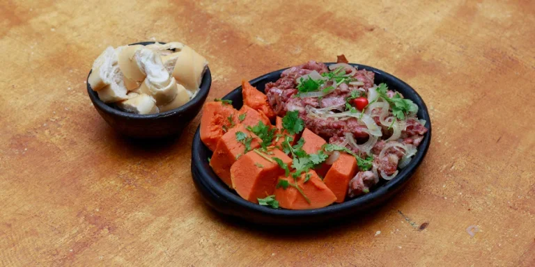 Un cuenco de comida con una cuchara y un tenedor.