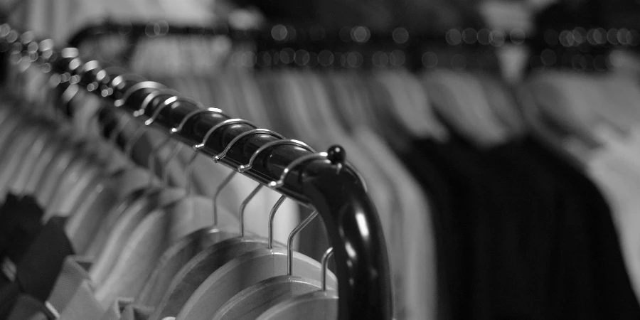 Black and white photo of clothes hanging on racks