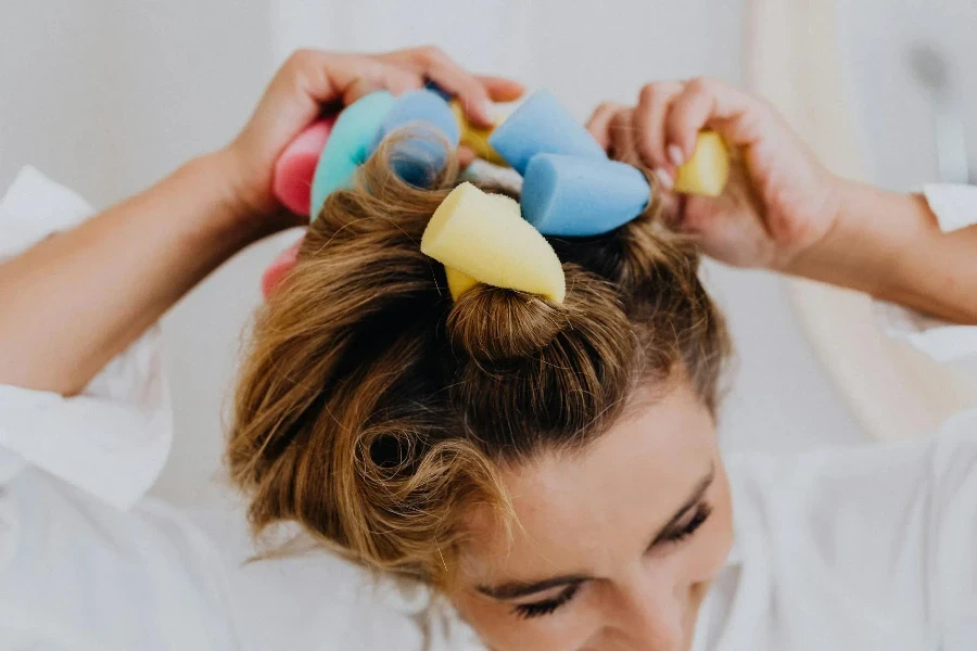 Woman Fixing Her Hair Using Hair Rods Curlers